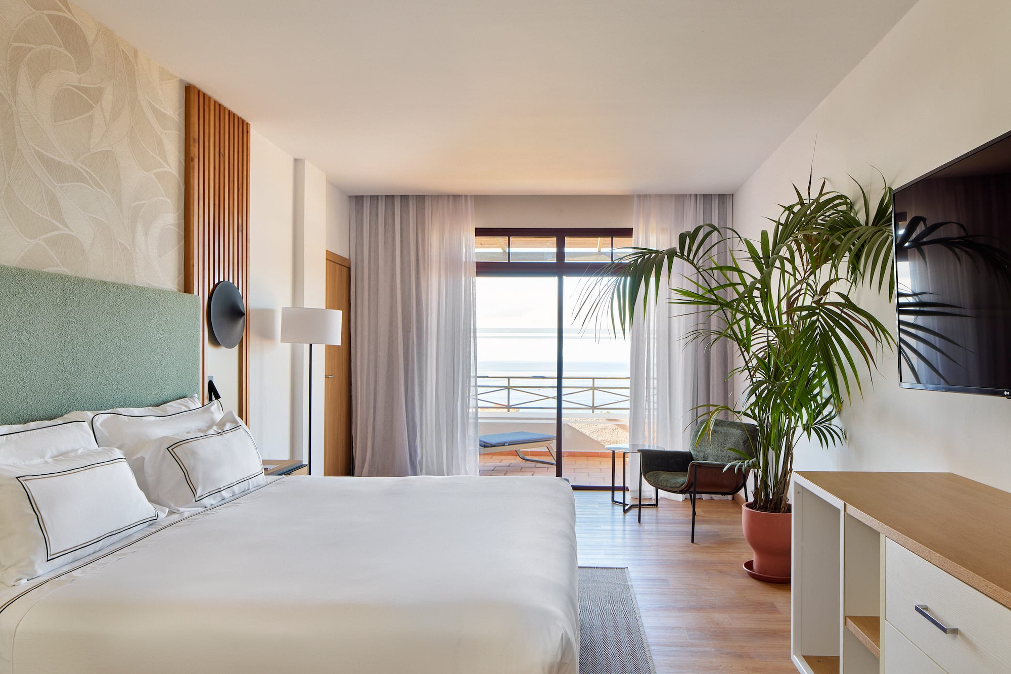 a bedroom with a large bed and a plant