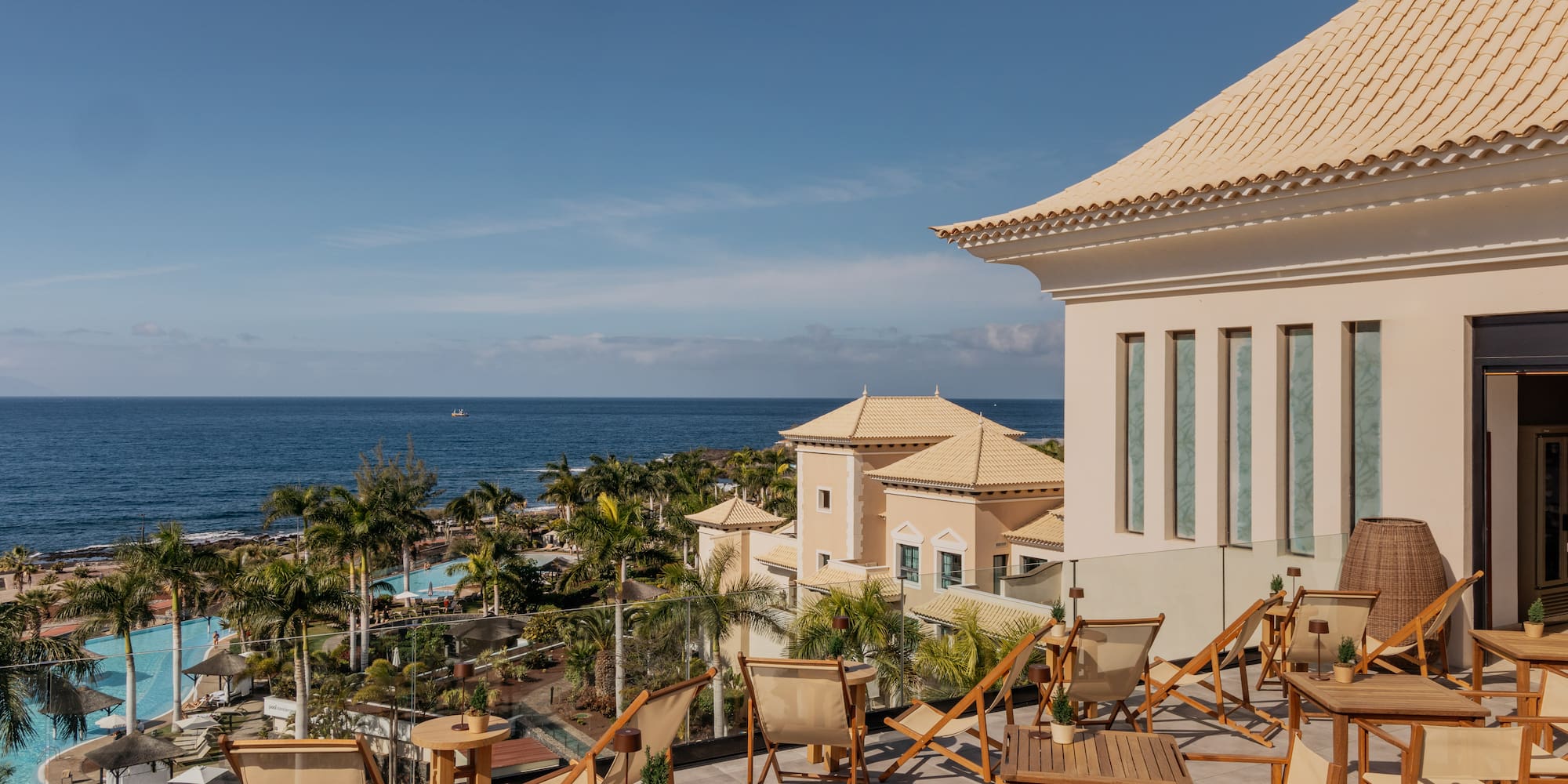a deck chairs and a building with a body of water in the background