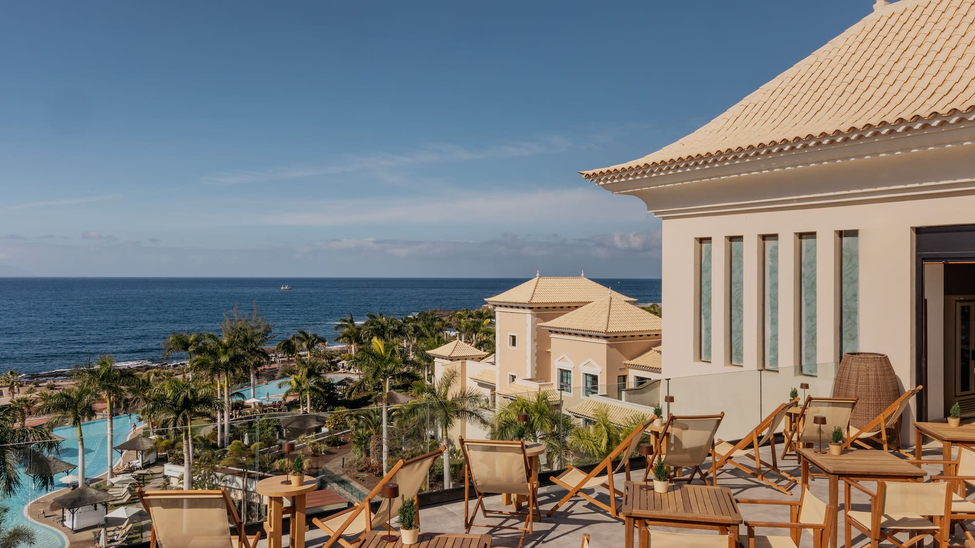 a deck chairs and a building with a body of water in the background