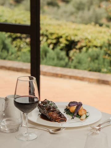 a plate of food and wine glass on a table