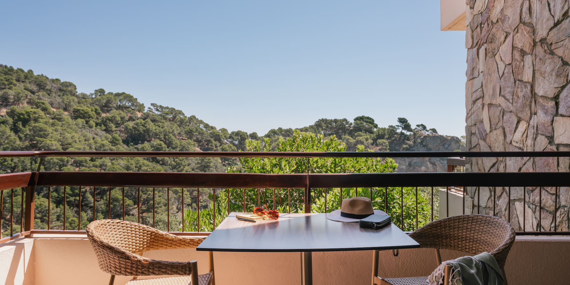 a table and chairs on a balcony overlooking trees