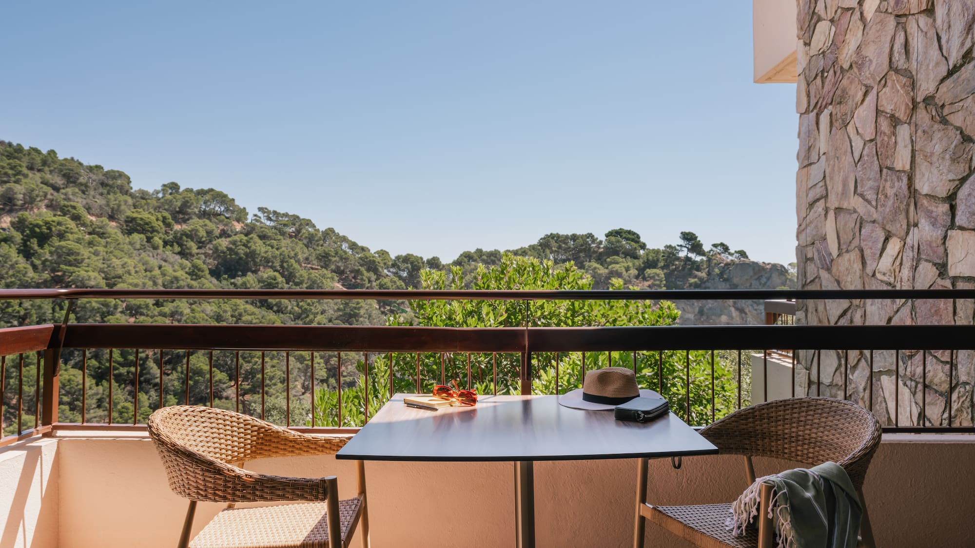 a table and chairs on a balcony overlooking trees