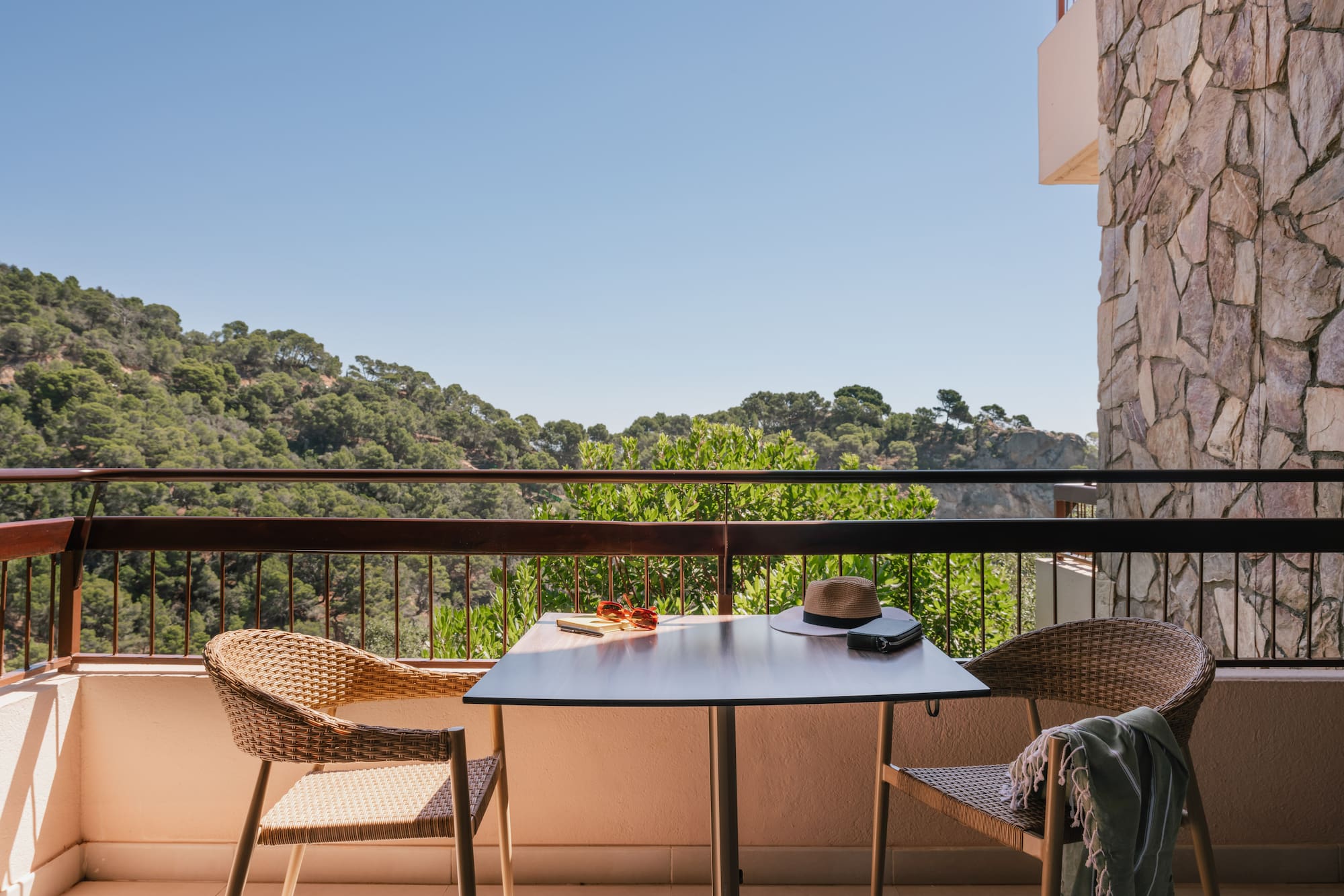 a table and chairs on a balcony overlooking trees