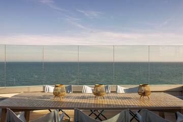 a table with chairs and a view of the ocean