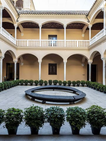 a courtyard with a circular bench and potted plants