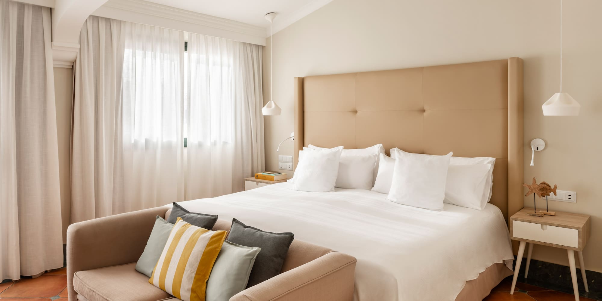 a bed with pillows and a couch in a room