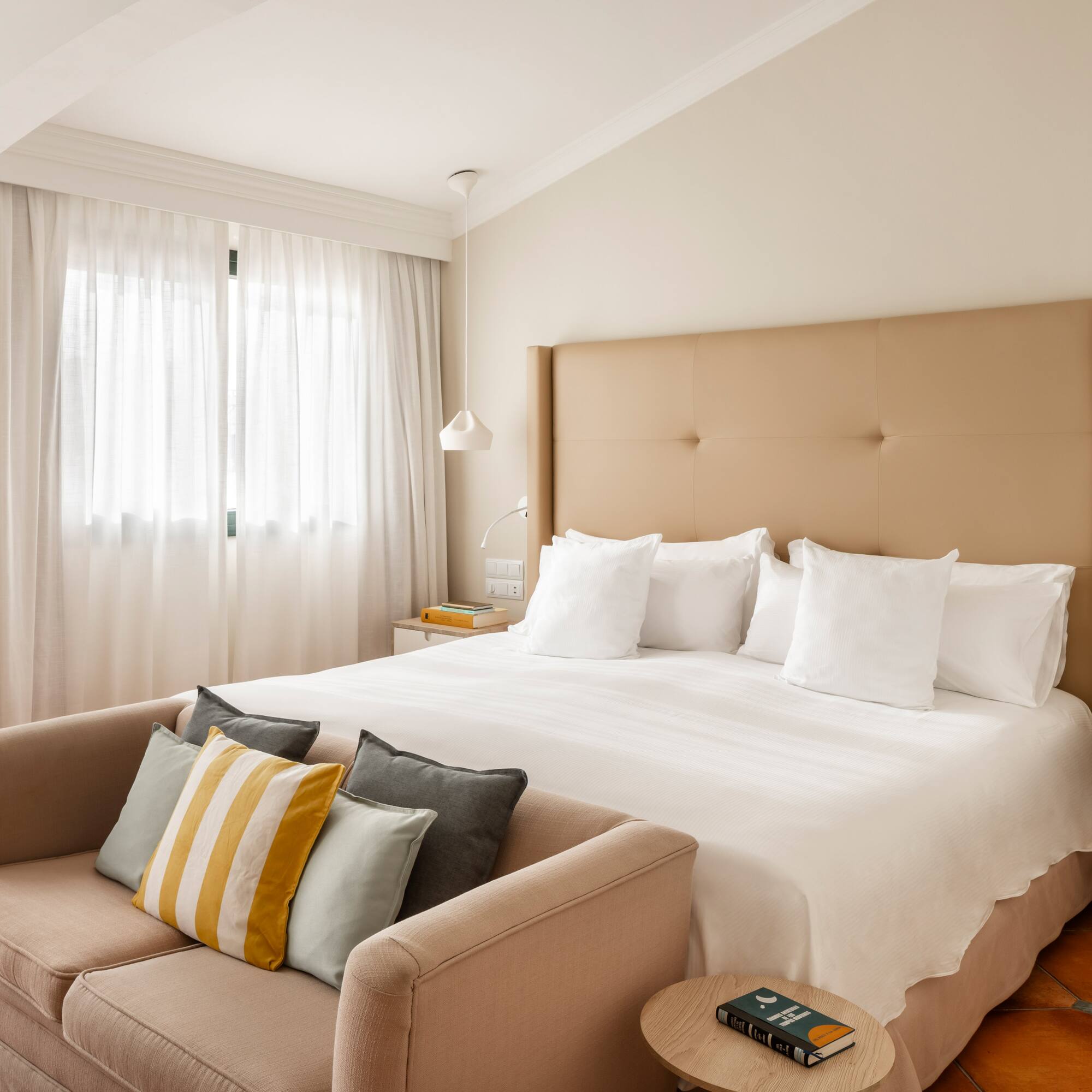 a bed with pillows and a couch in a room