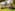 Historic villa garden with fountain, outdoor event setup, and flowering arch.