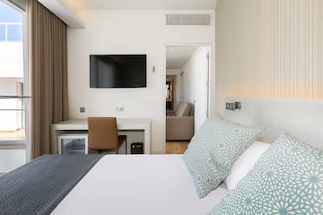 a bed with pillows and a tv on the wall