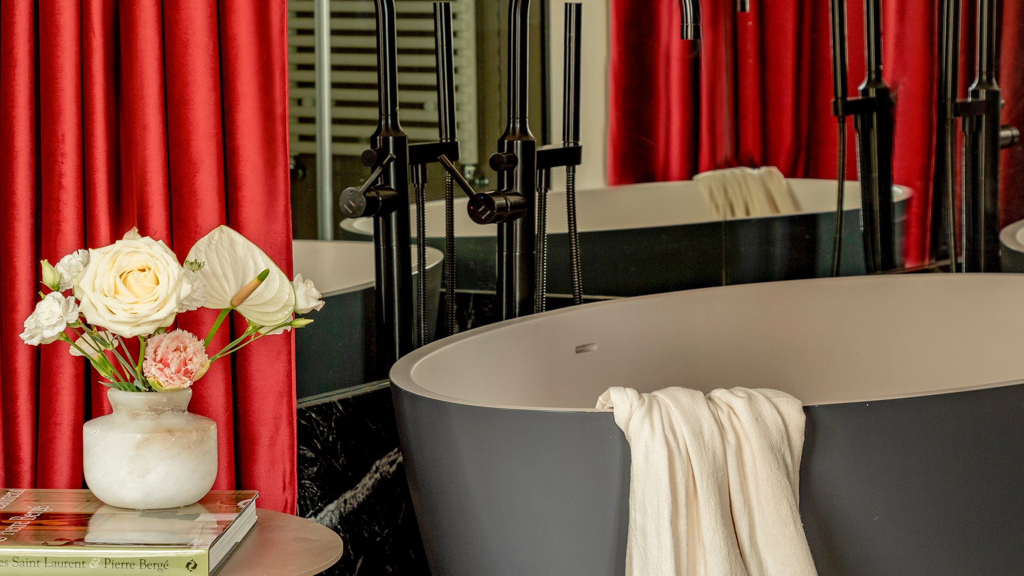 a tub and a vase of flowers in a bathroom