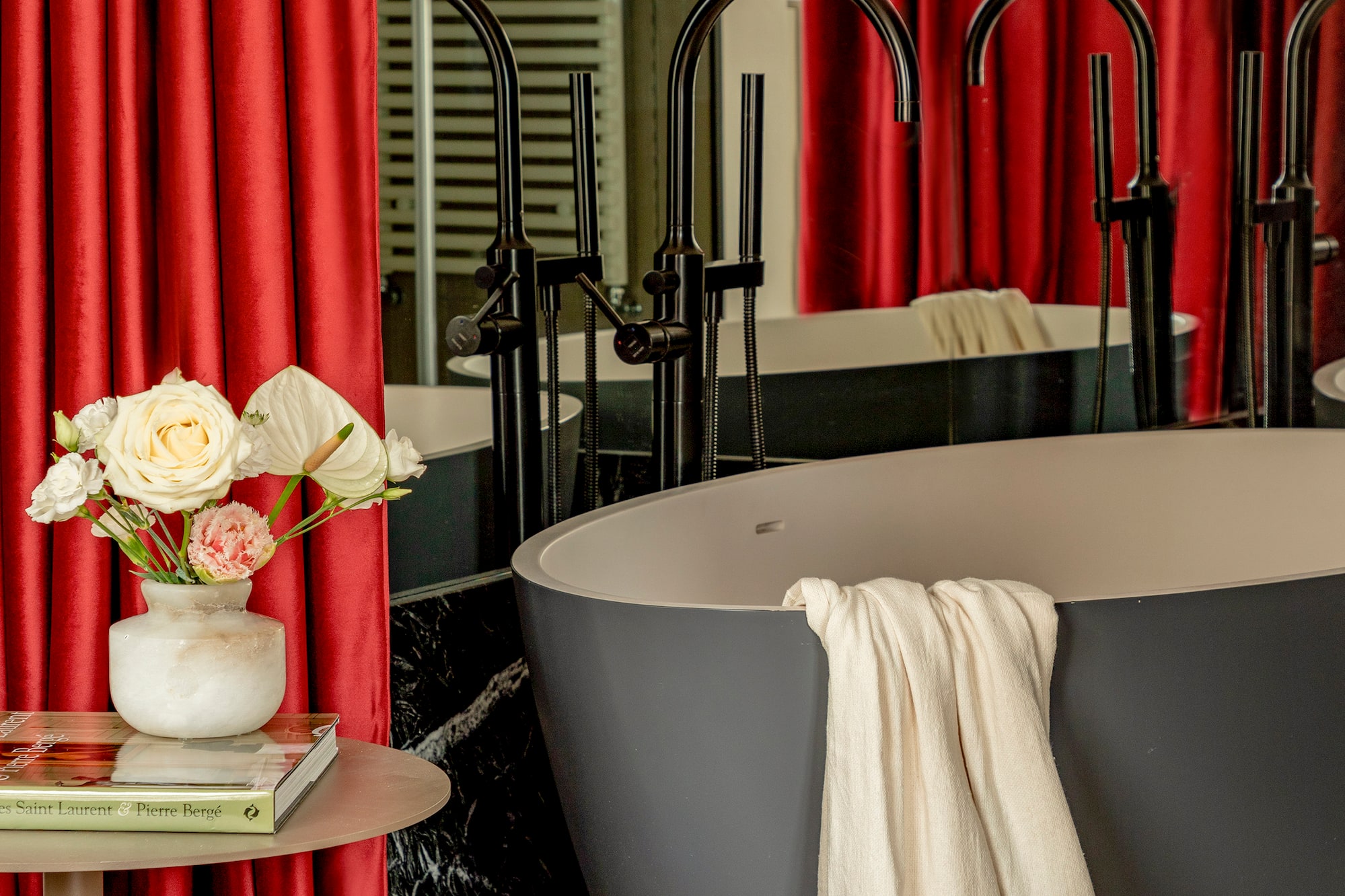 a tub and a vase of flowers in a bathroom