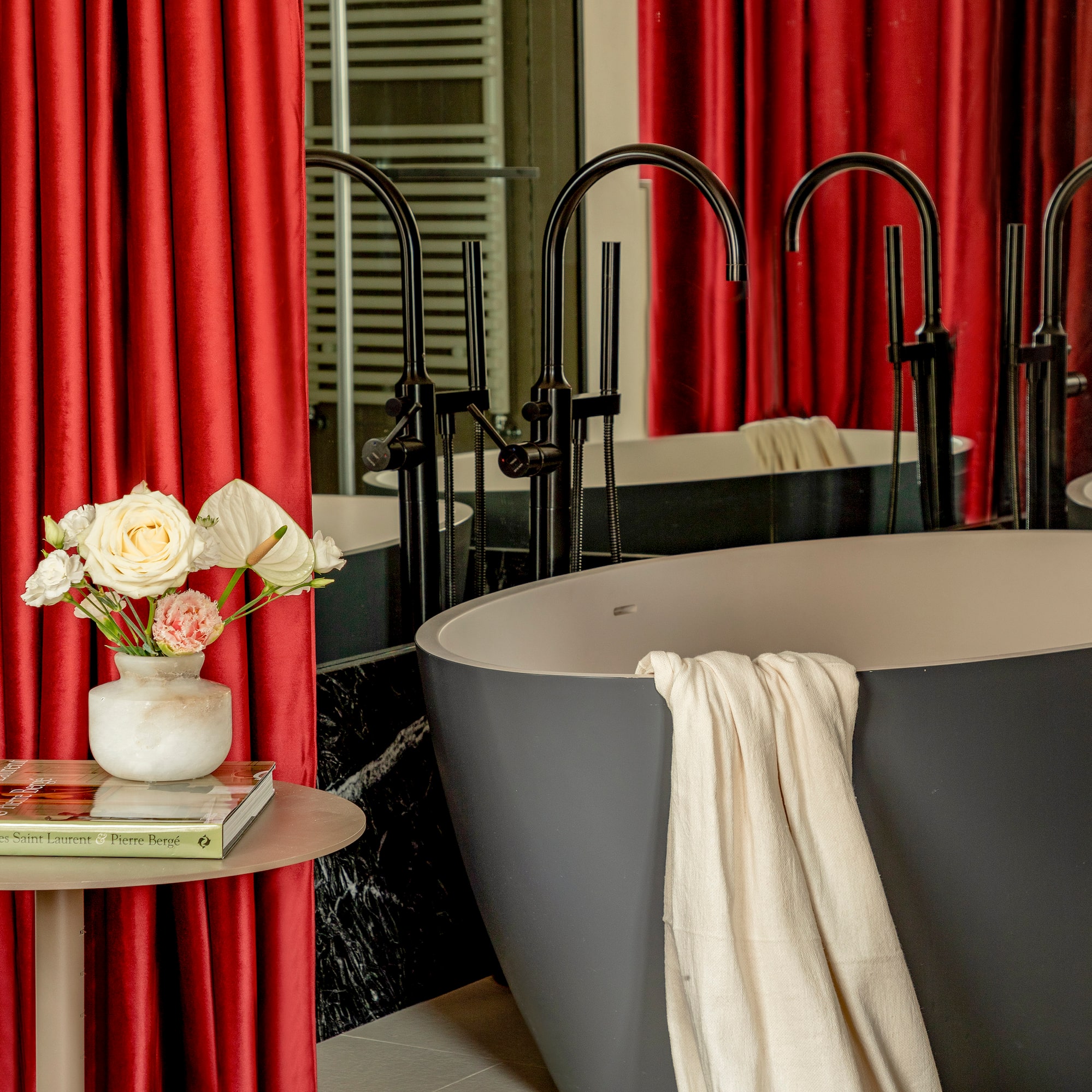 a tub and a vase of flowers in a bathroom
