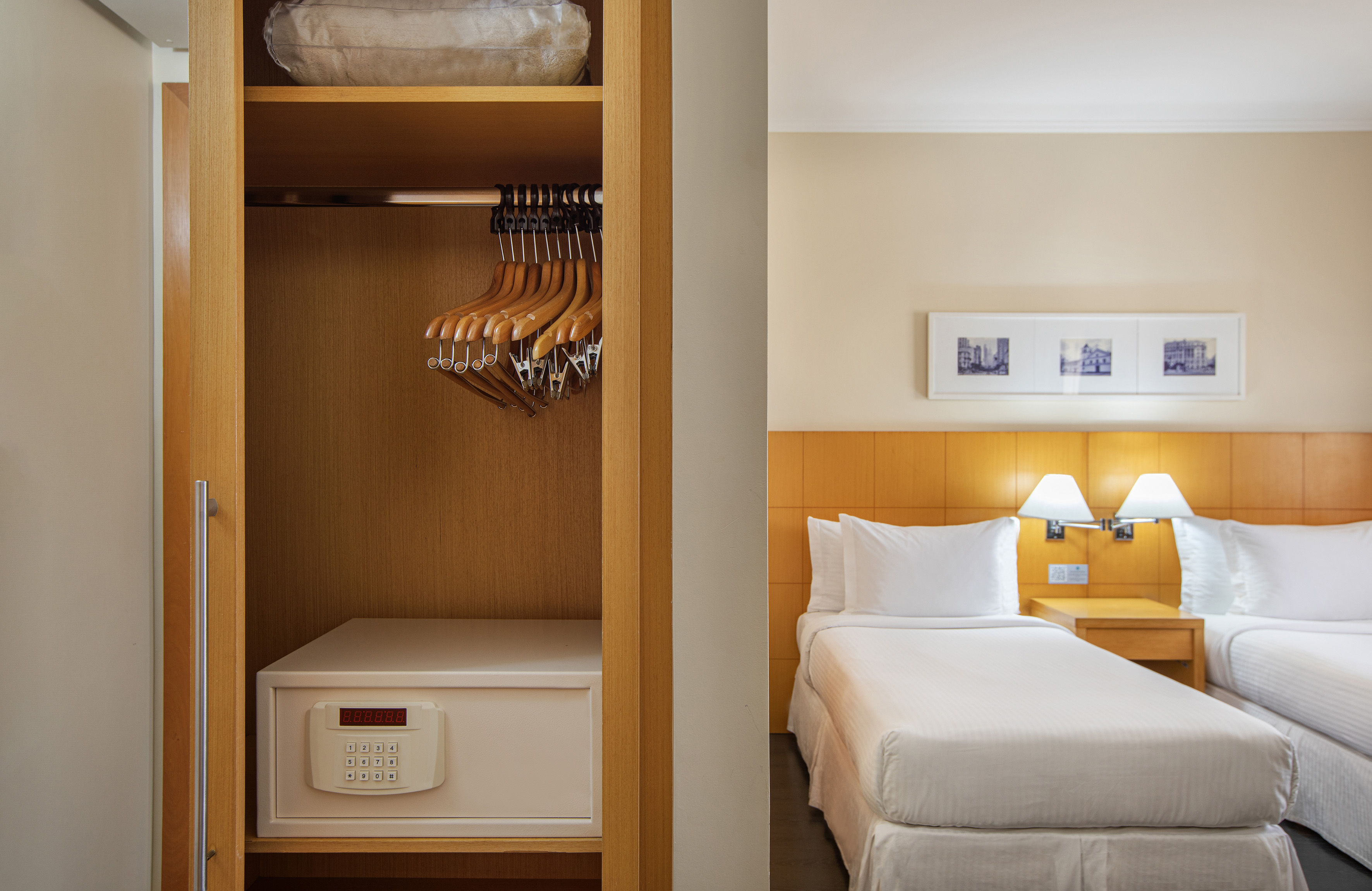Hotel bedroom with wardrobe, in-room safe, hangers, and two twin beds.