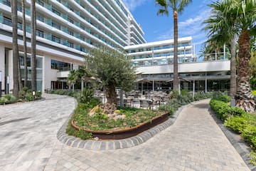 a courtyard of a hotel with palm trees and a large building