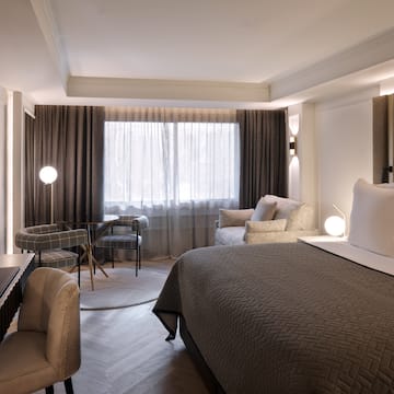 a room with a bed and a table and chairs