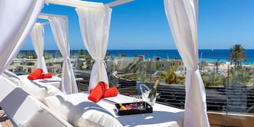 a white canopy with white curtains and a tray of towels on it