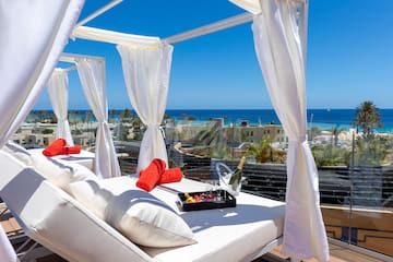 a white canopy with white curtains and a tray of towels on it