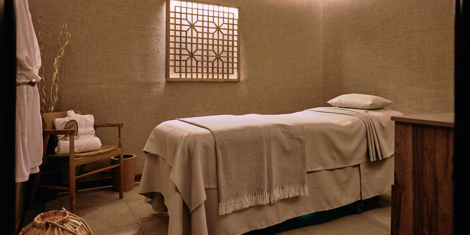 a massage room with a bed and a chair