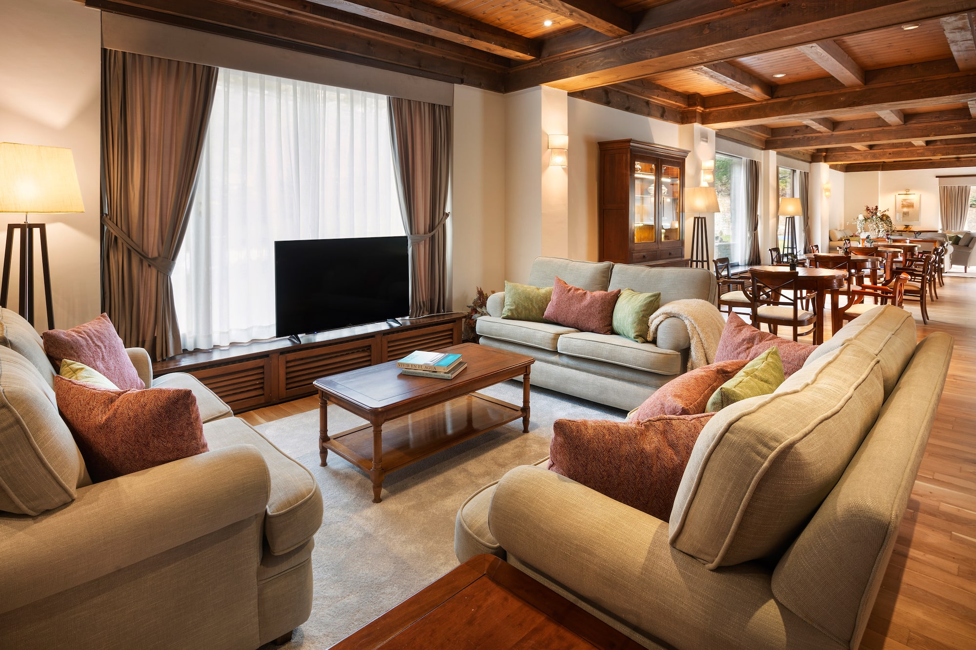 Warm, rustic hotel lobby with comfy sofas, wood ceiling, and lounge tables.