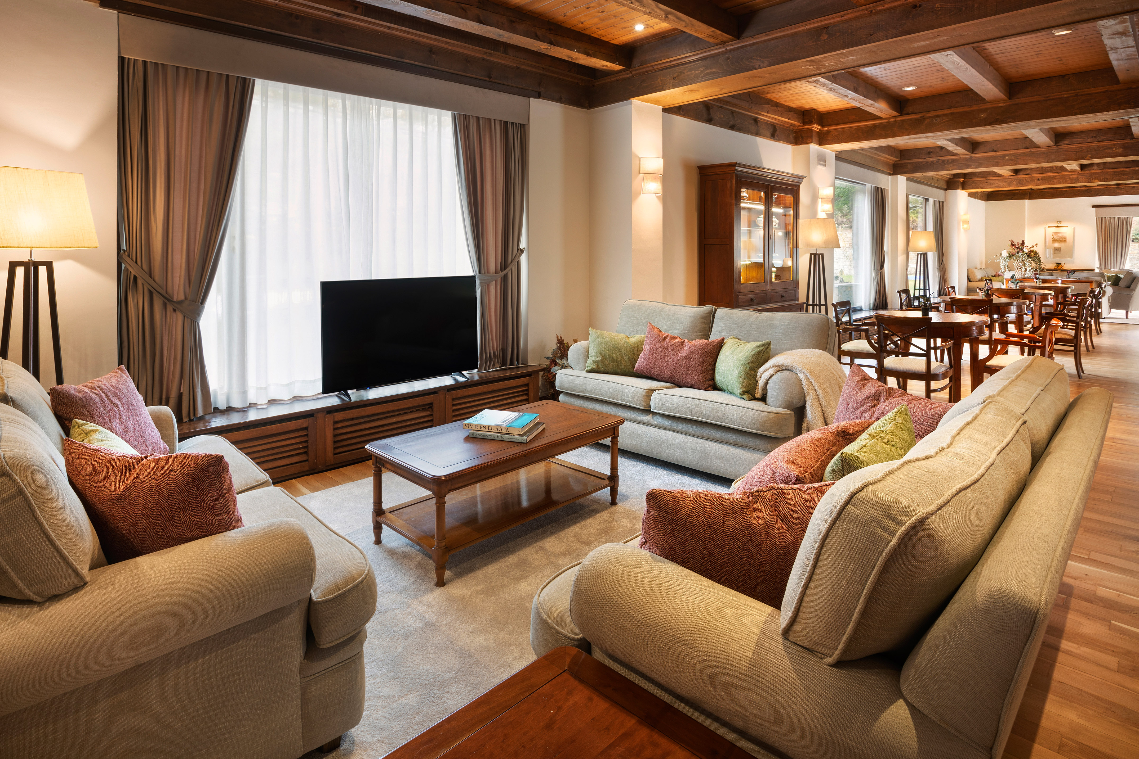 Warm, rustic hotel lobby with comfy sofas, wood ceiling, and lounge tables.