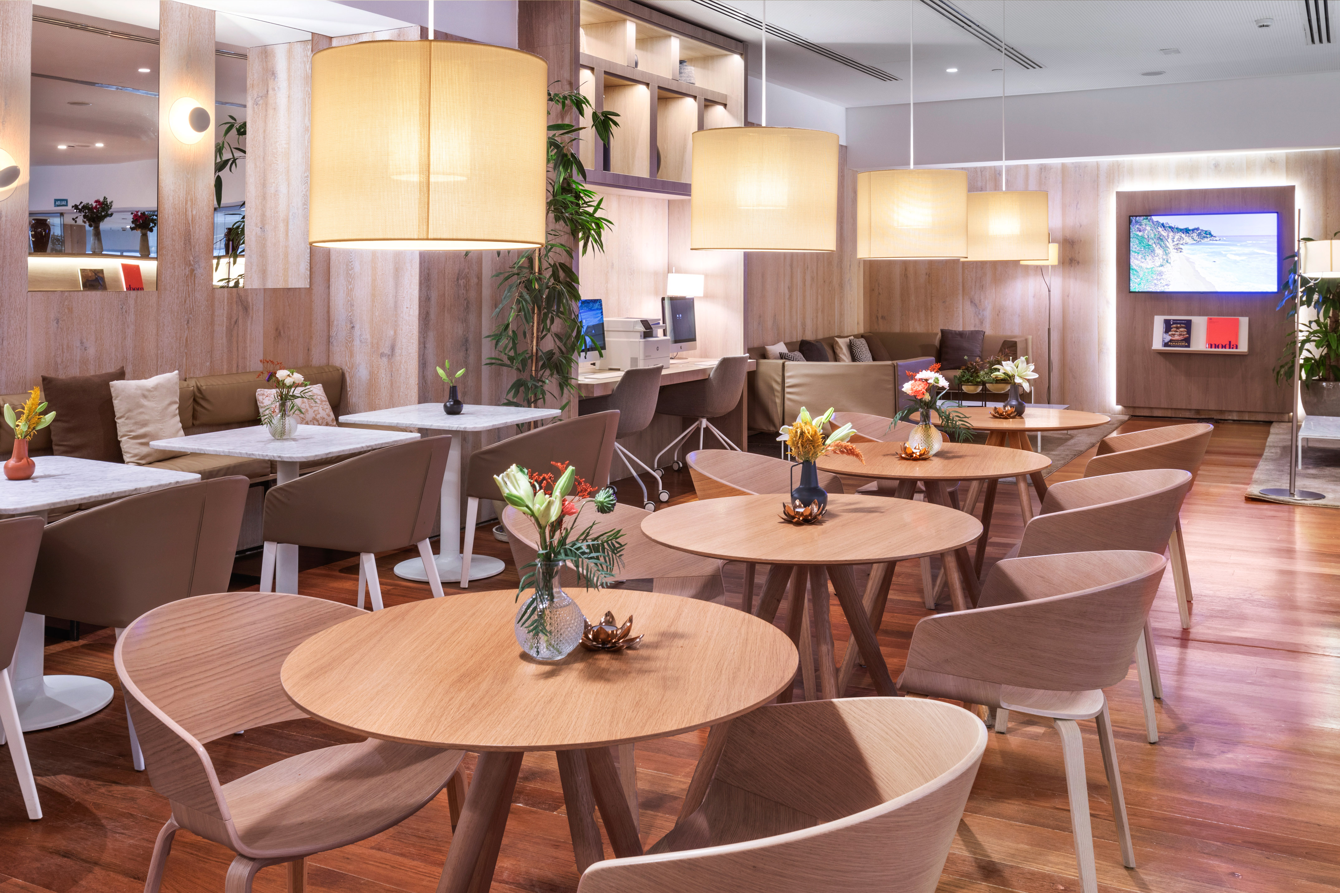 Elegant lounge interior with wooden tables, cozy seating, and warm lighting.