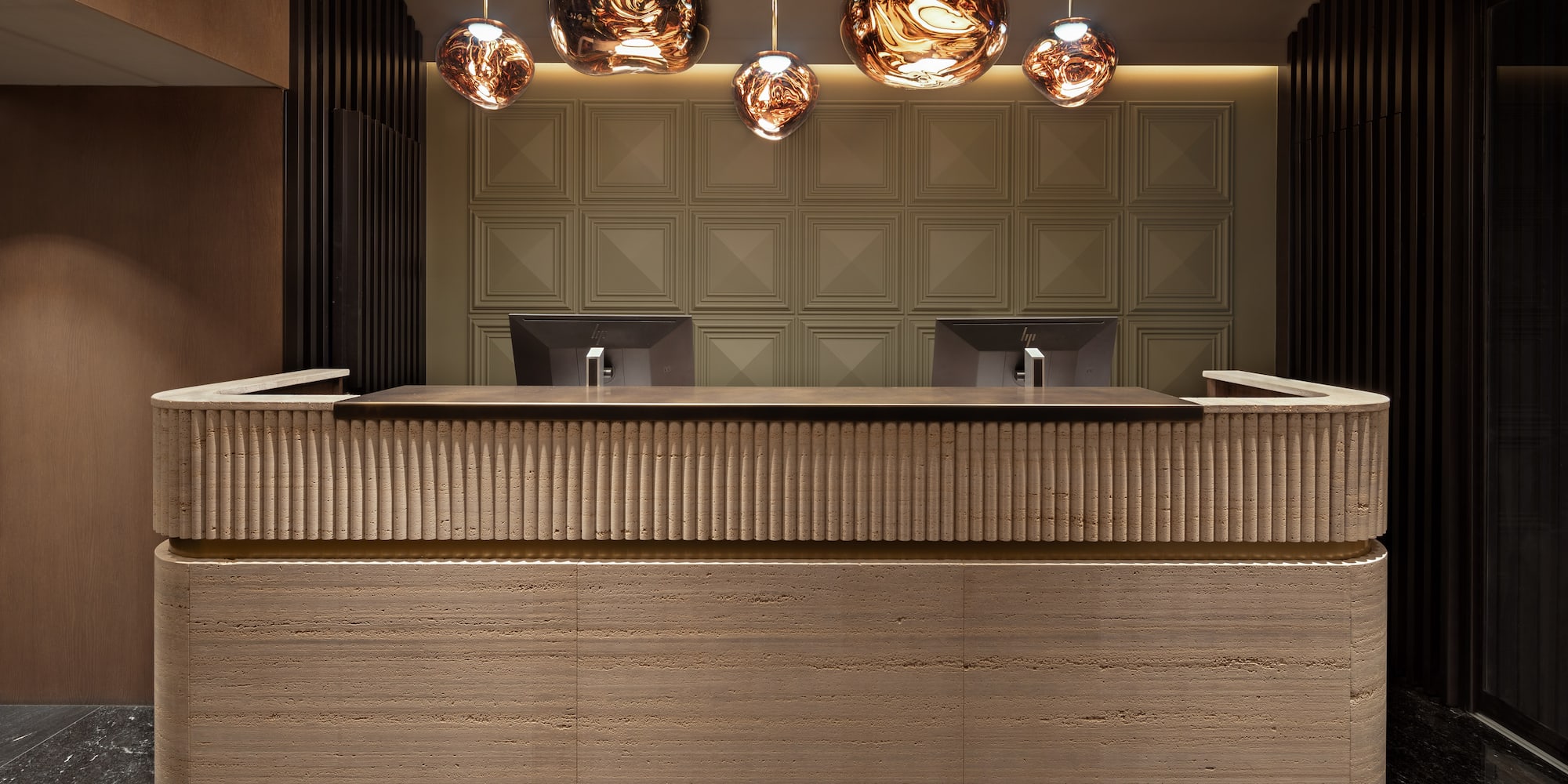 a reception desk with a marble counter and lights