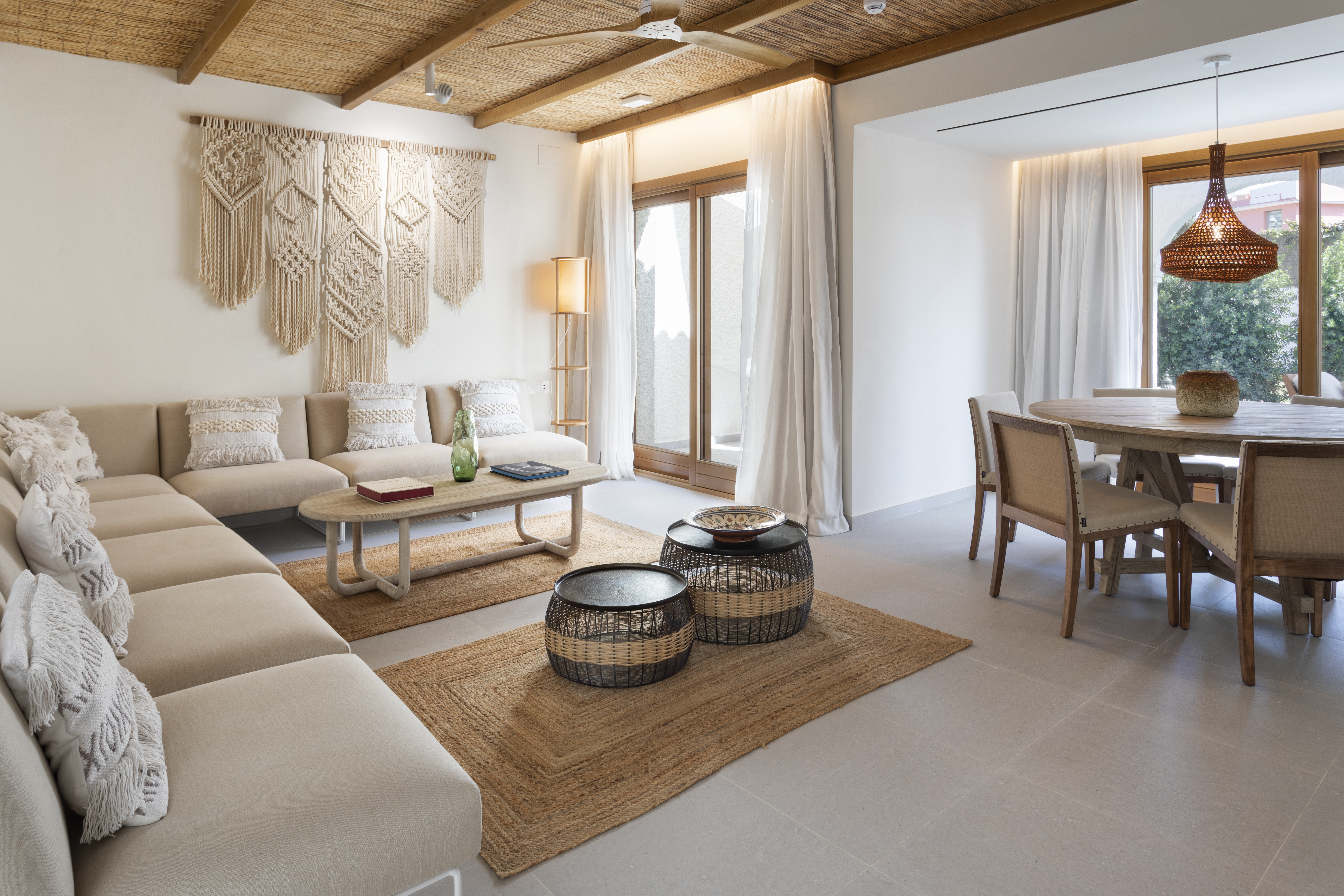 Boho living & dining room: macrame, jute rugs, natural wood furniture.