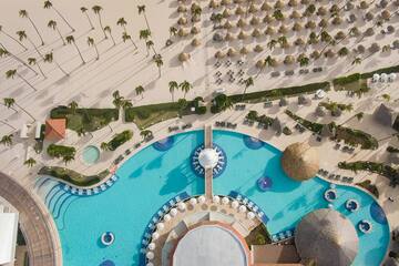 an aerial view of a resort with a pool and palm trees