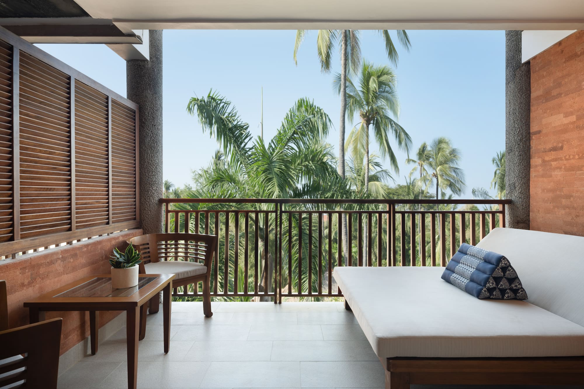 a balcony with a bed and a bench