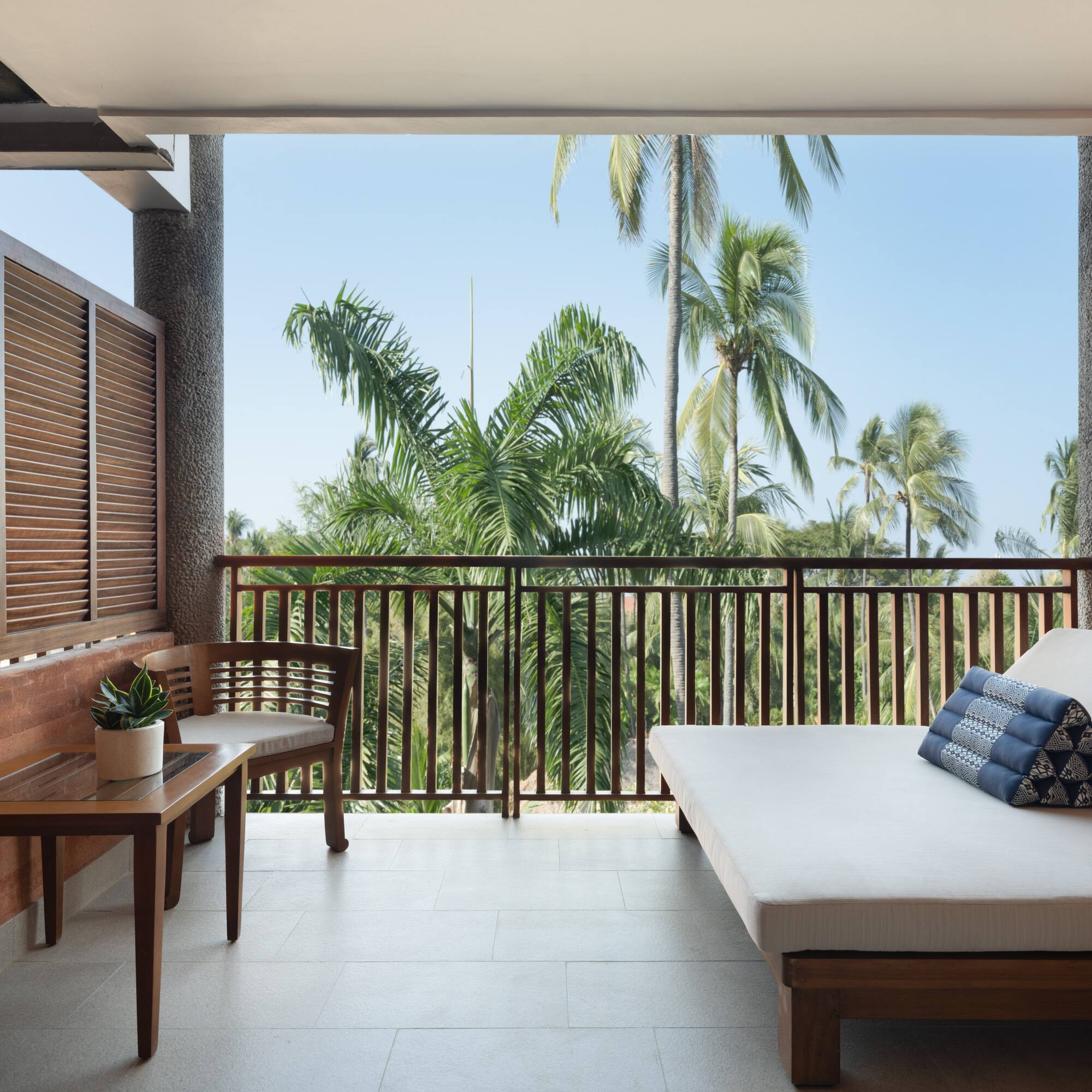 a balcony with a bed and a bench