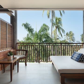 a balcony with a bed and a bench