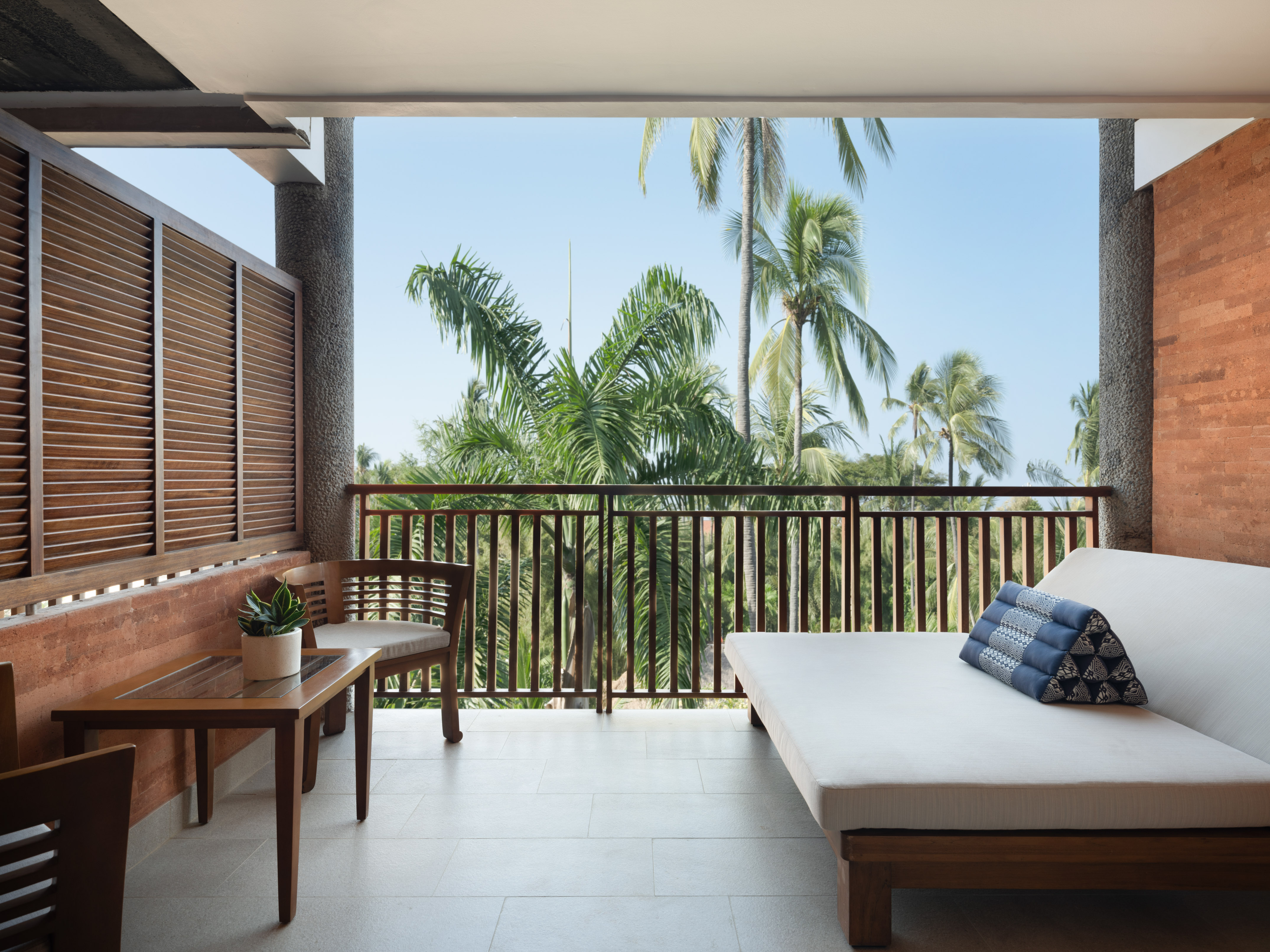 a balcony with a bed and a bench