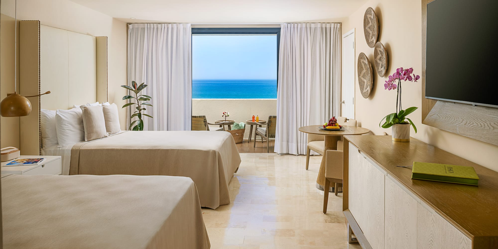 a room with two beds and a table and chairs