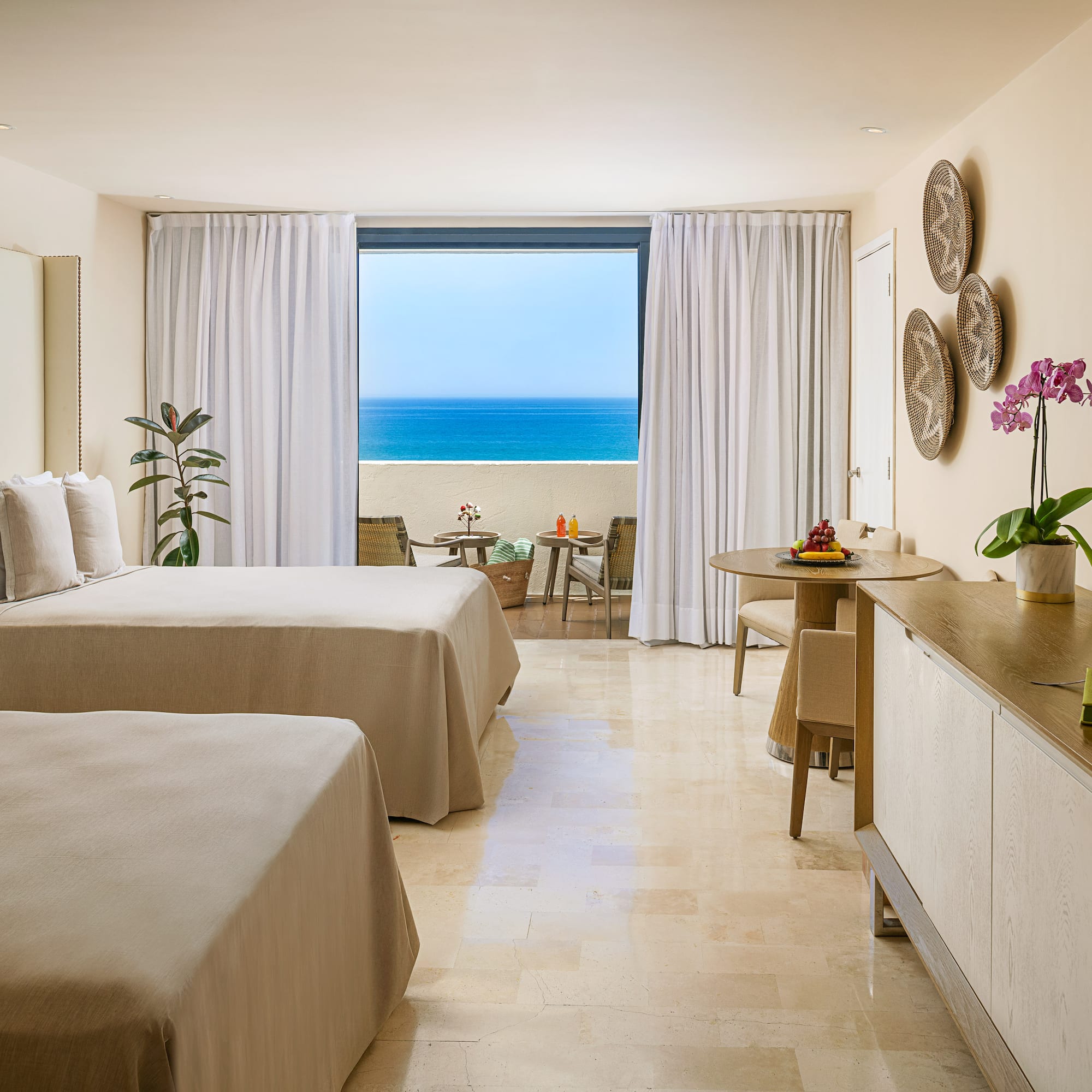 a room with two beds and a table and chairs