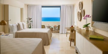 a room with two beds and a table and chairs