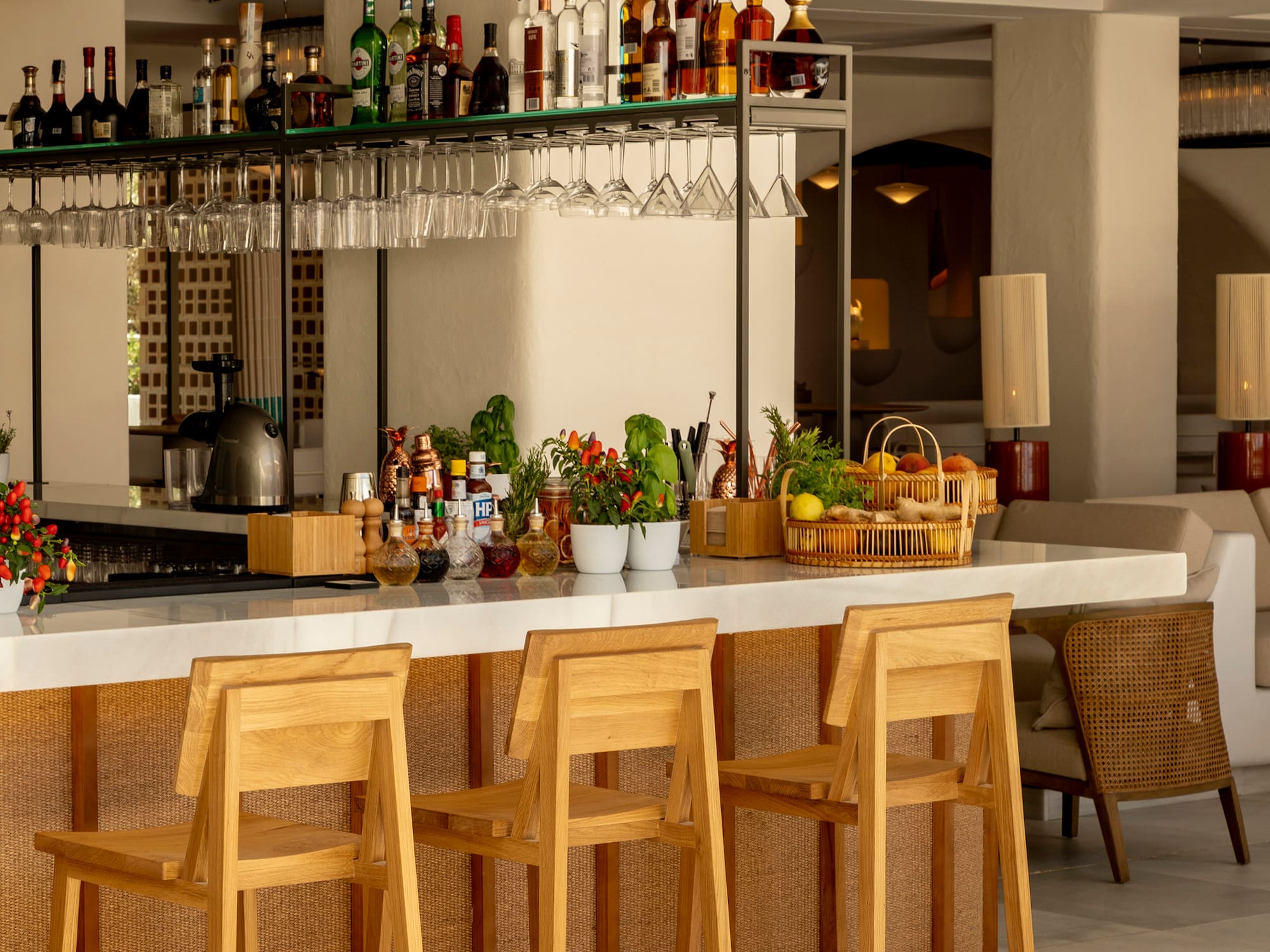 a bar with chairs and bottles on the counter