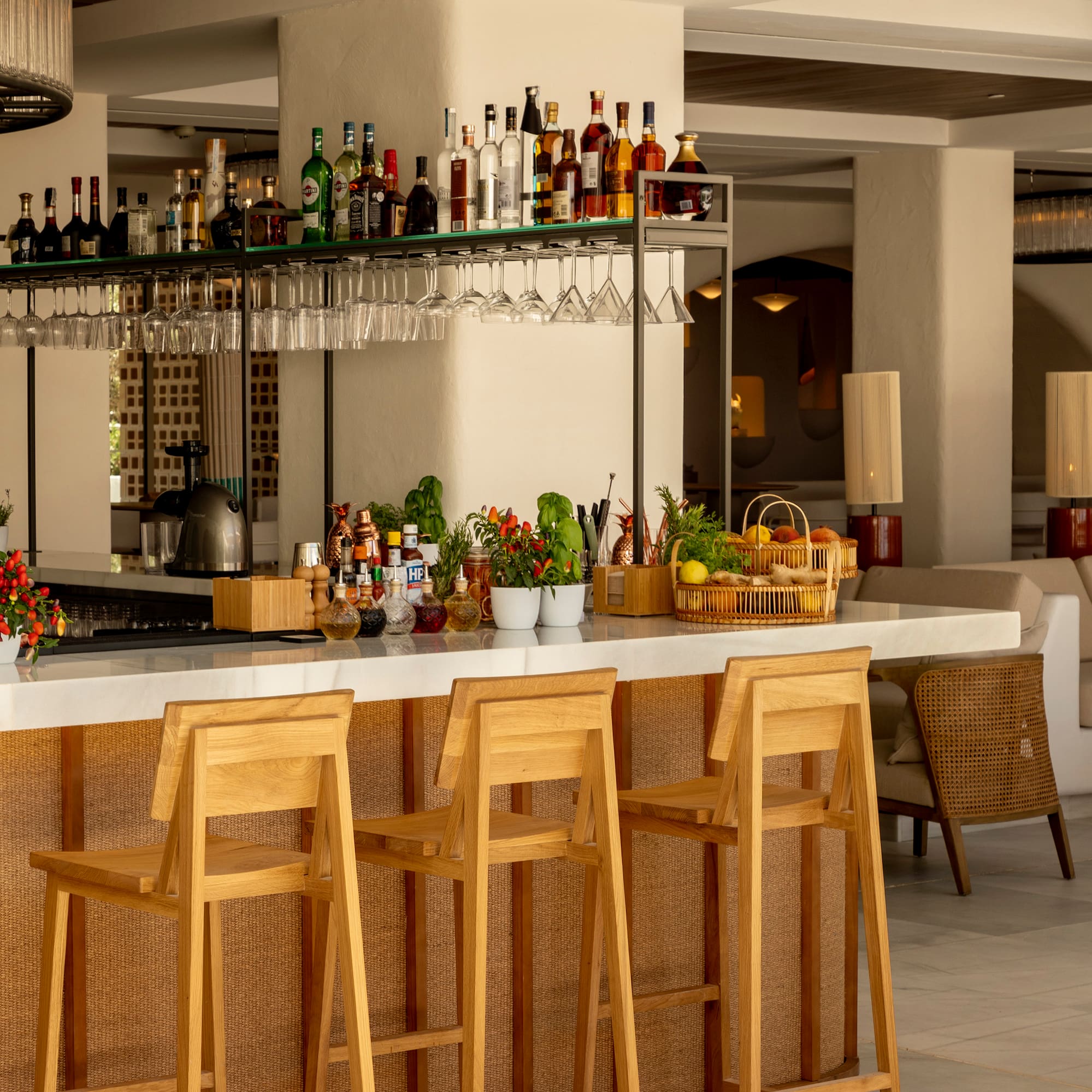 a bar with chairs and bottles on the counter