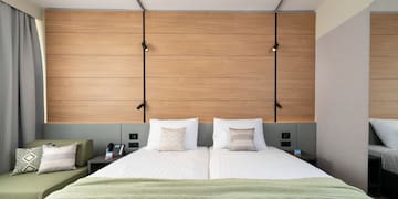 a bed with pillows and a green couch