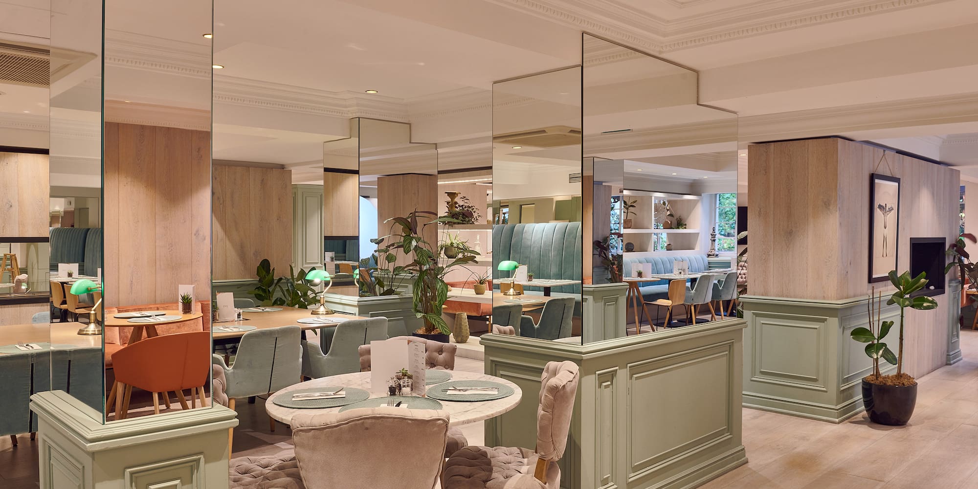 a room with a large mirror wall and tables and chairs