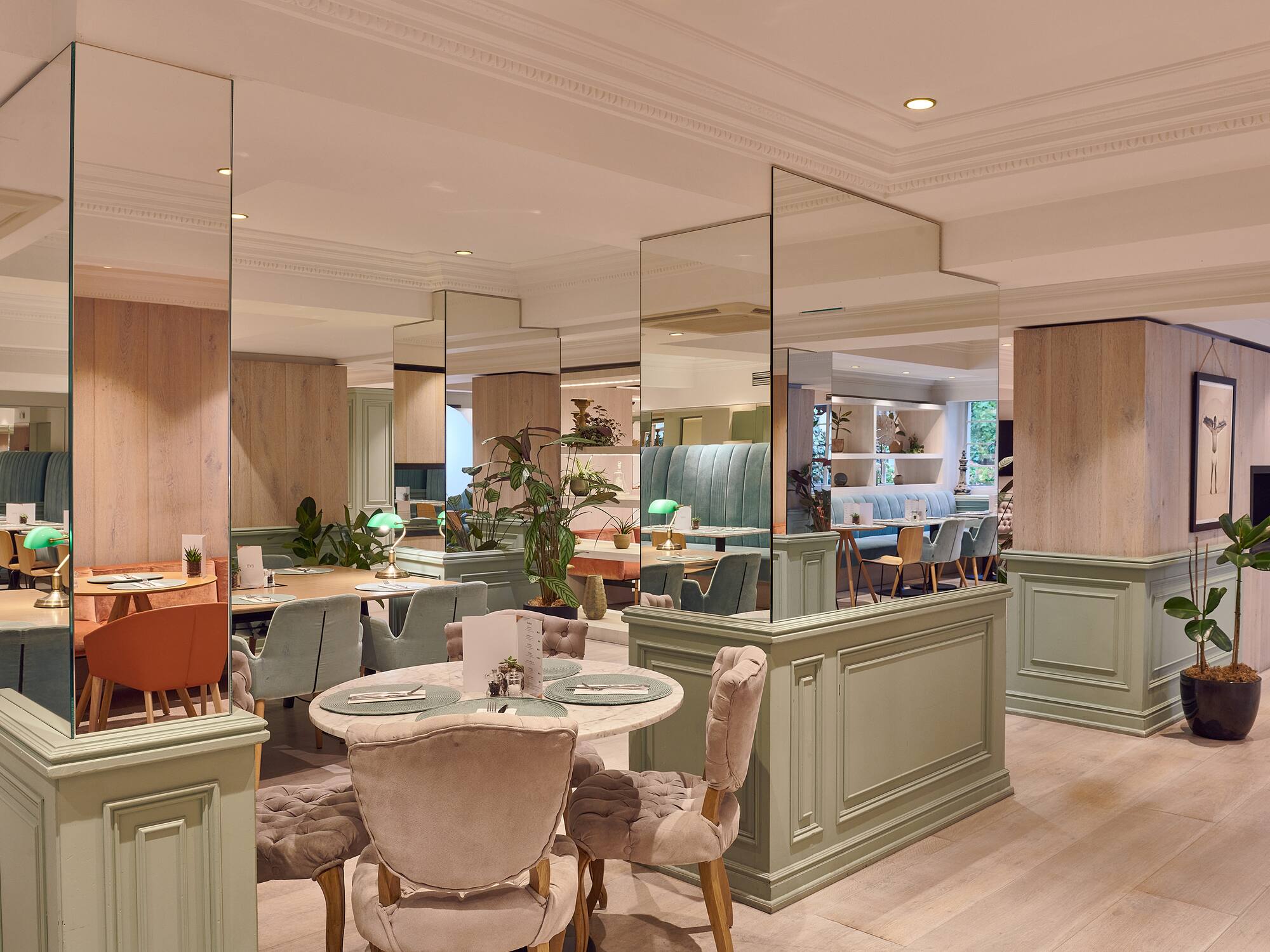 a room with a large mirror wall and tables and chairs