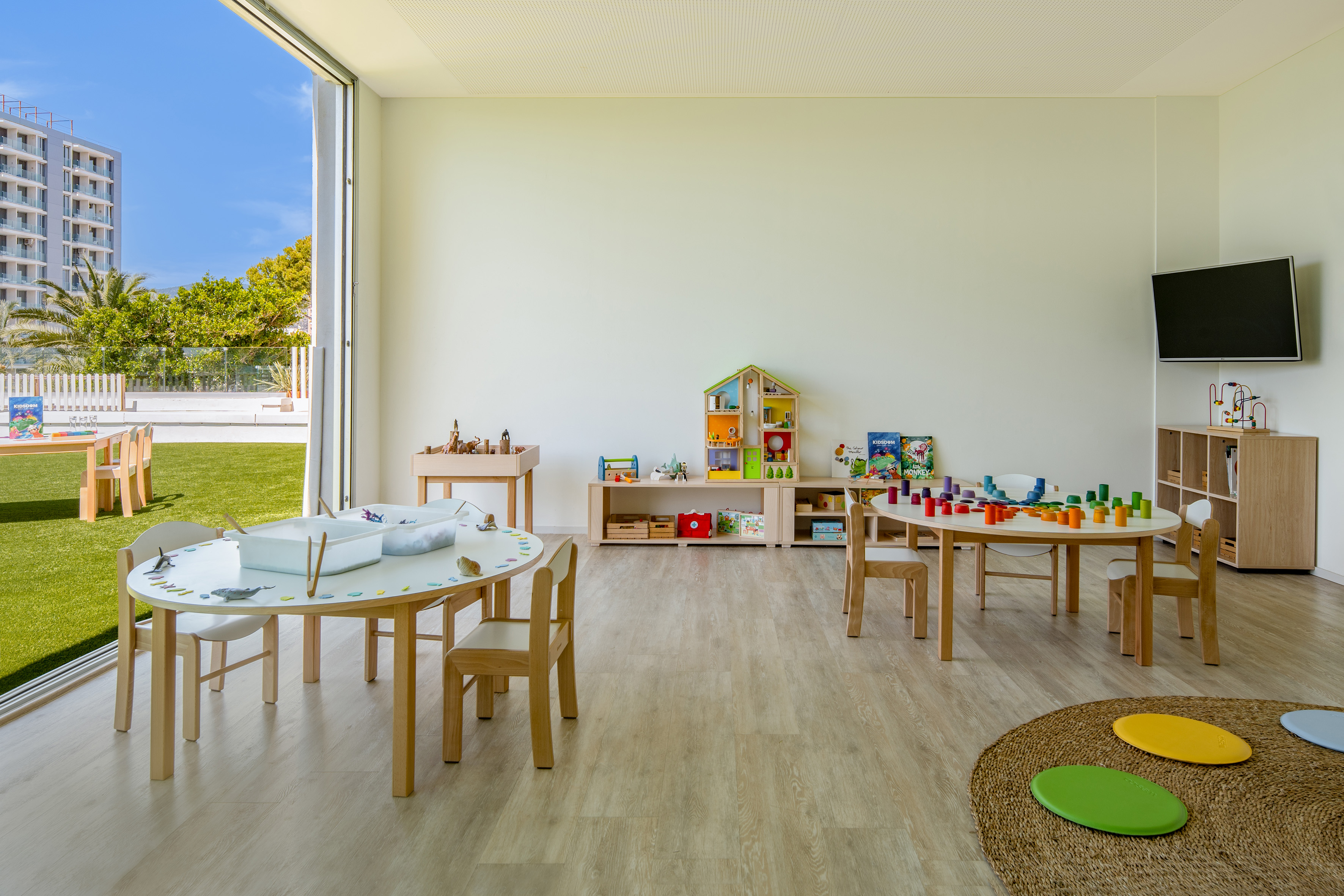 Spacious children's playroom with activity tables, educational toys, and outdoor access.