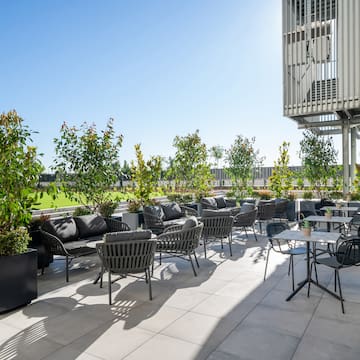 a patio with chairs and tables and trees