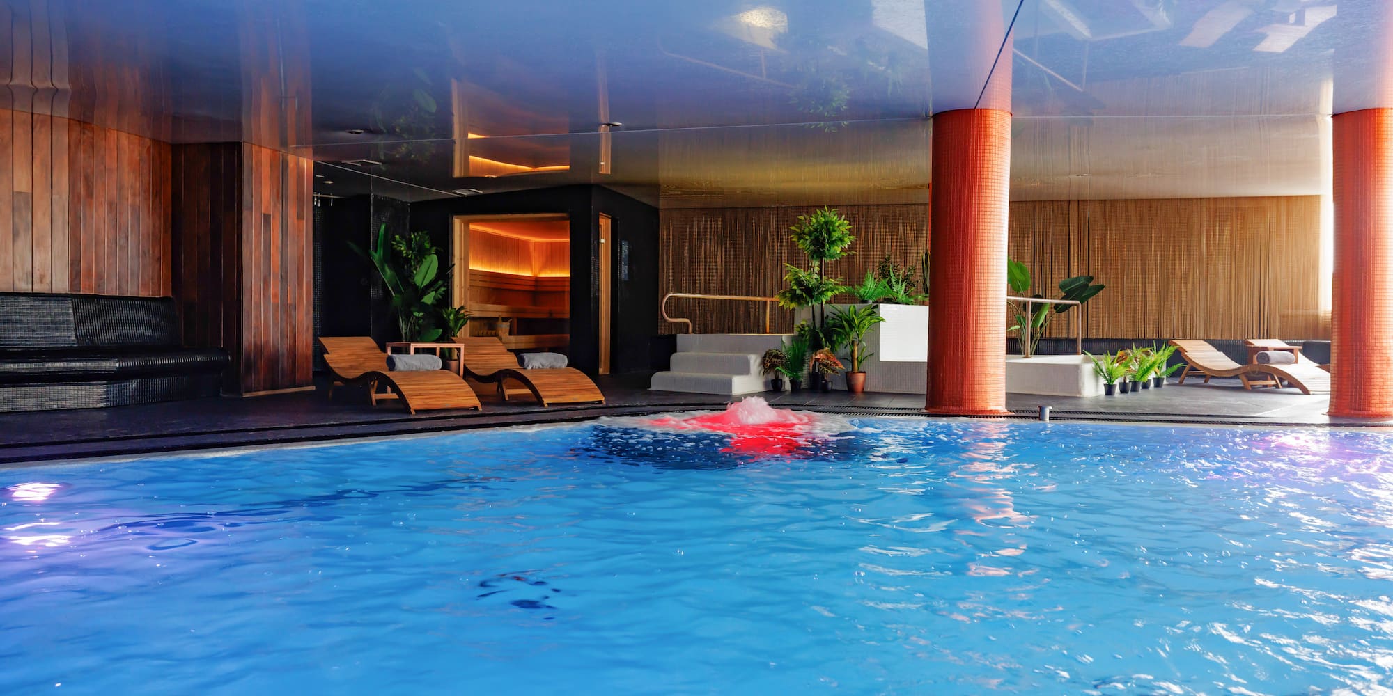 a pool with chairs and a red object in it