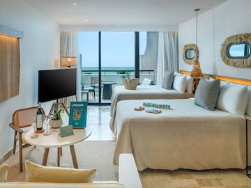 a room with two beds and a television