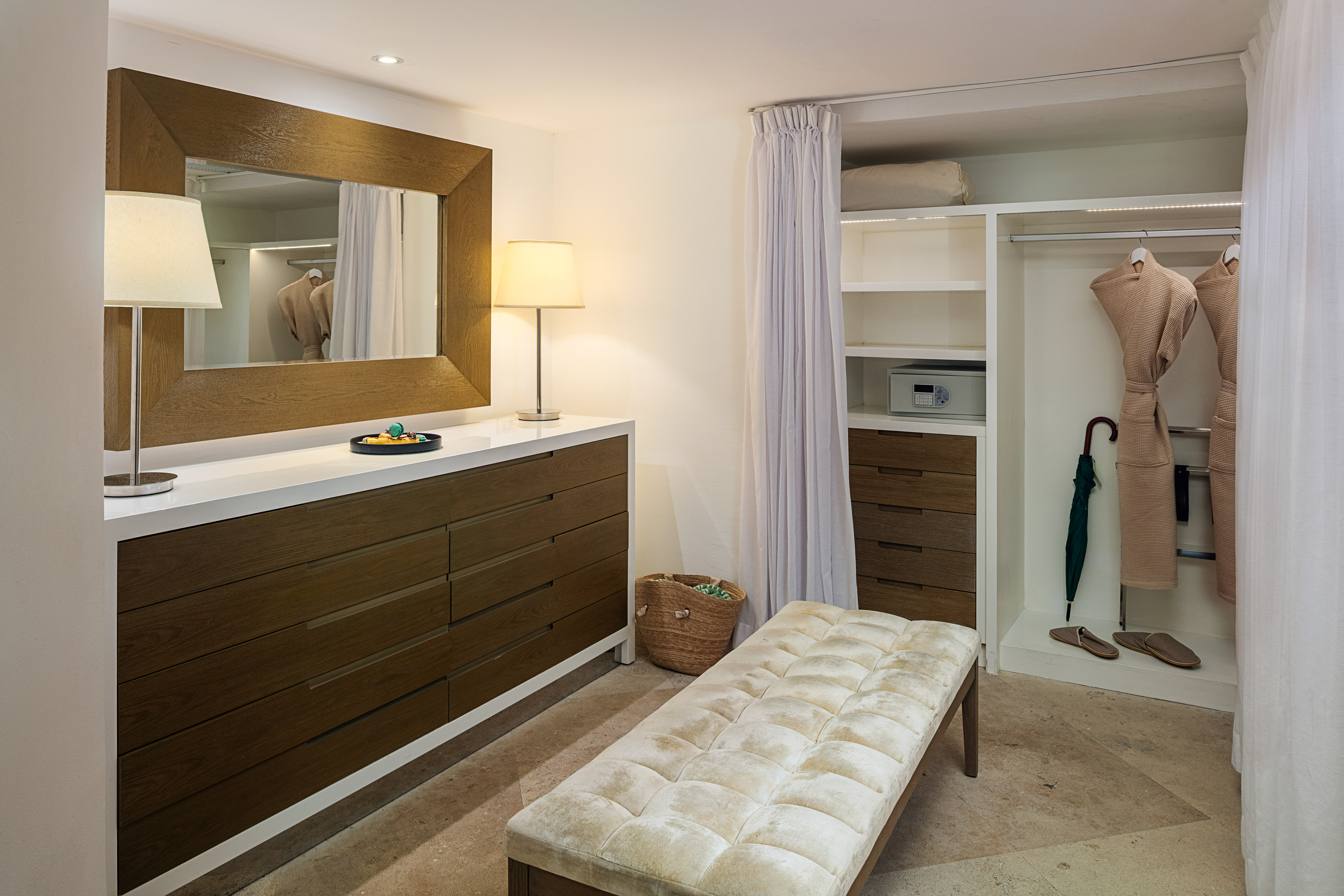 Modern walk-in closet with vanity, mirror, robes, and storage.