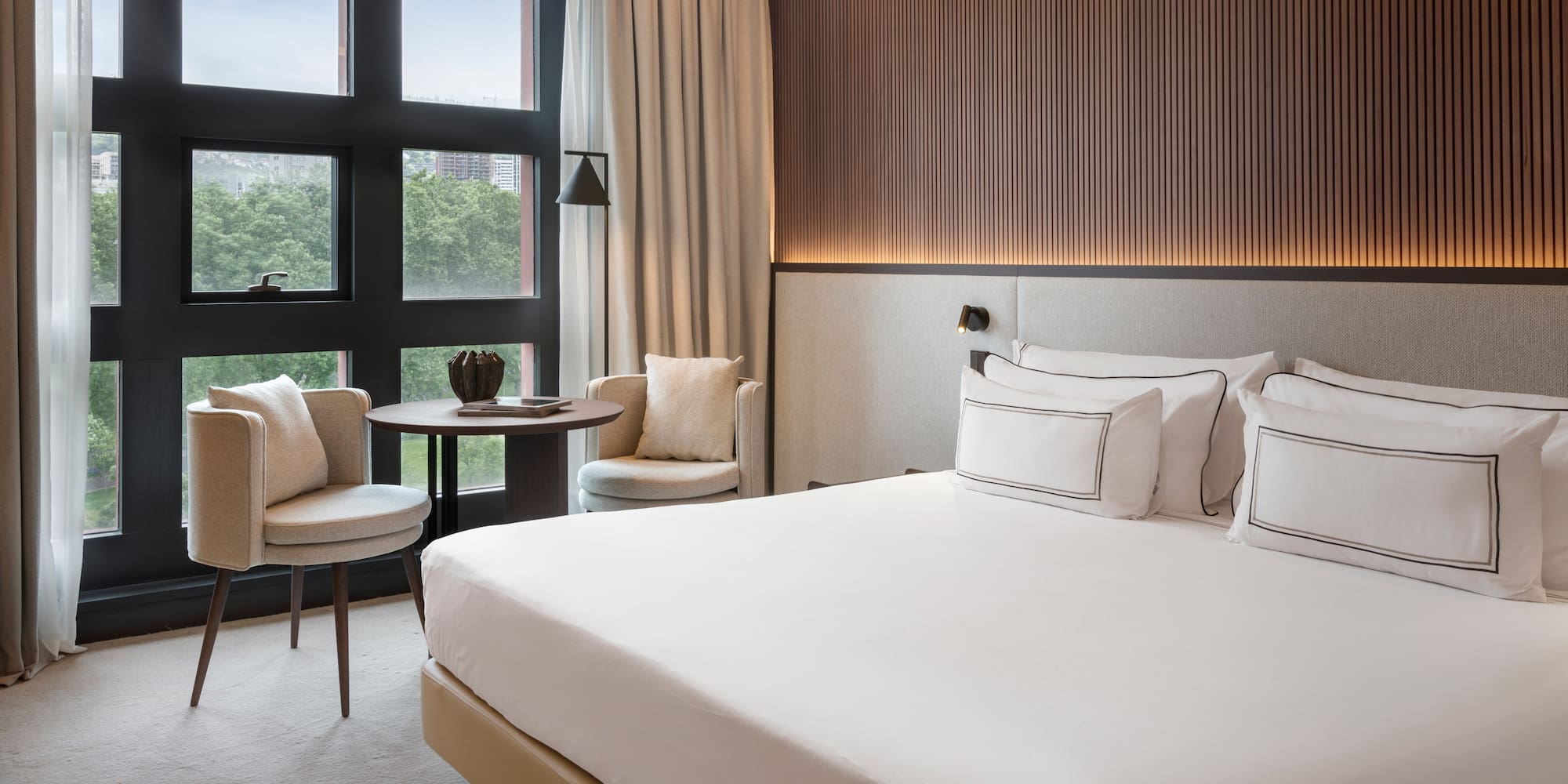 a room with a bed and chairs