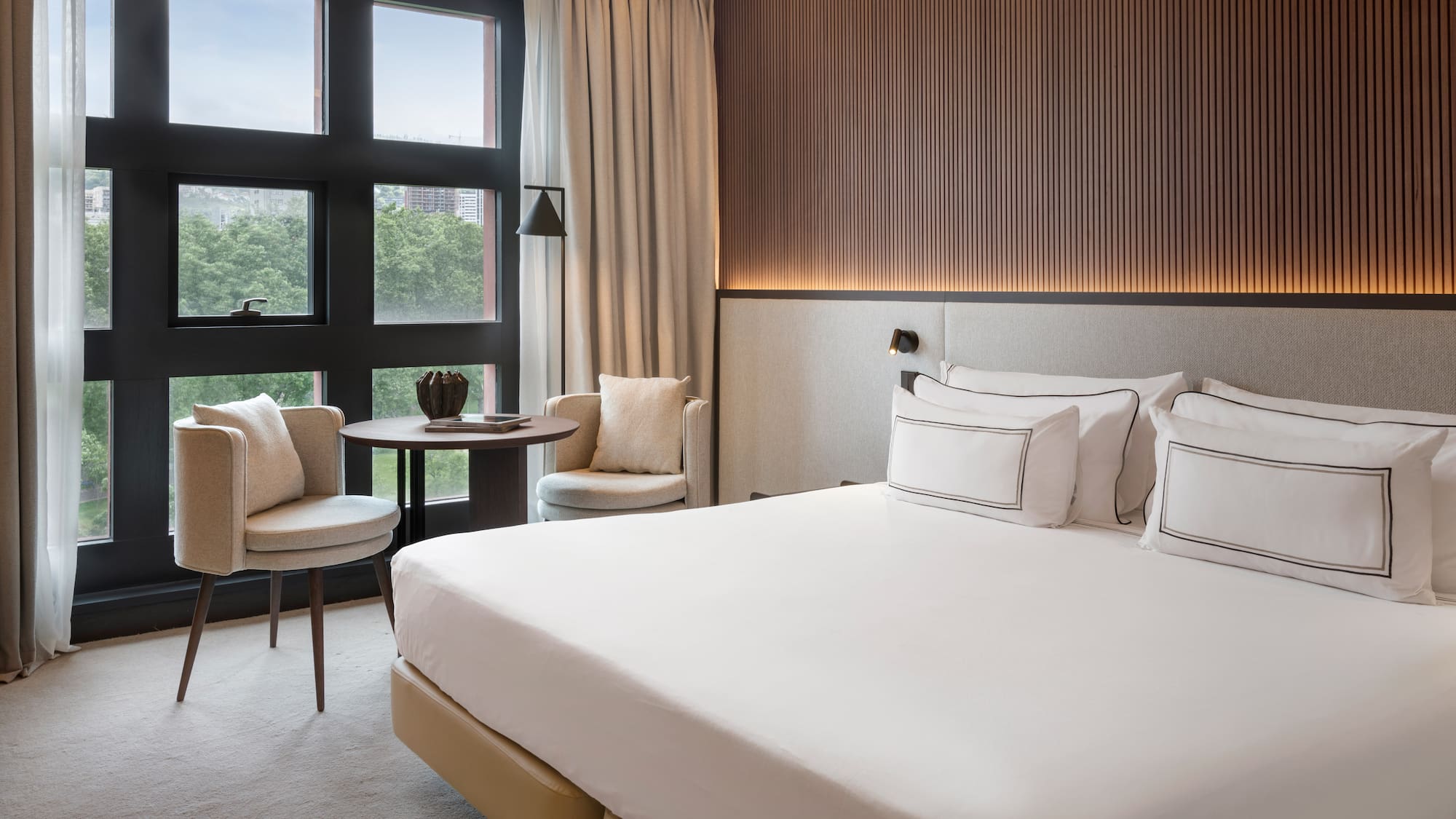 a room with a bed and chairs