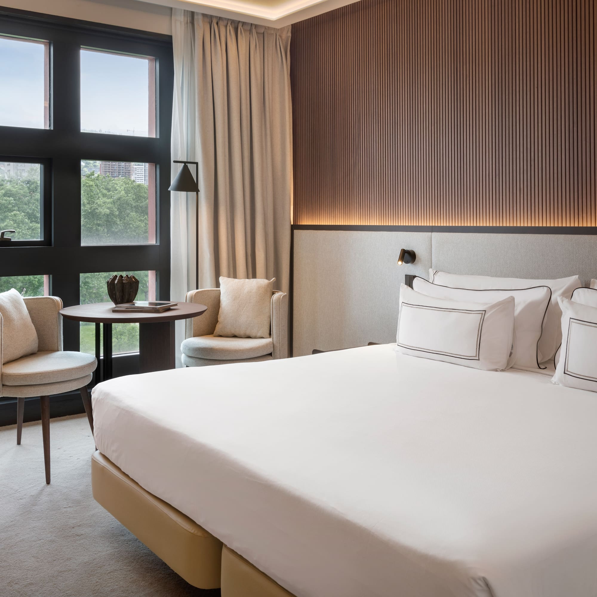 a room with a bed and chairs