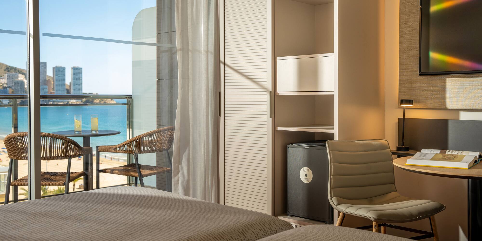 a room with a view of the ocean and a table and chairs