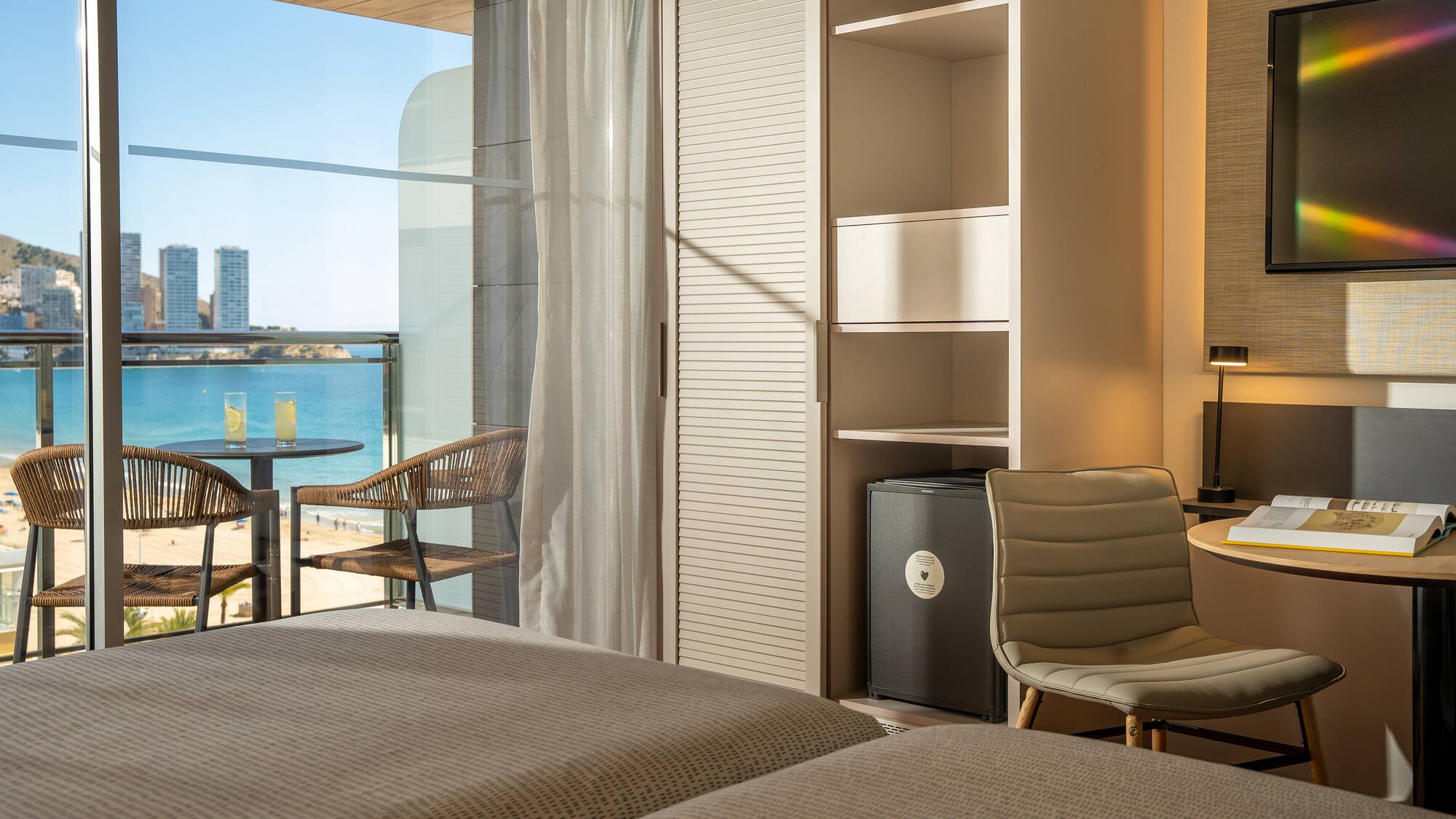 a room with a view of the ocean and a table and chairs